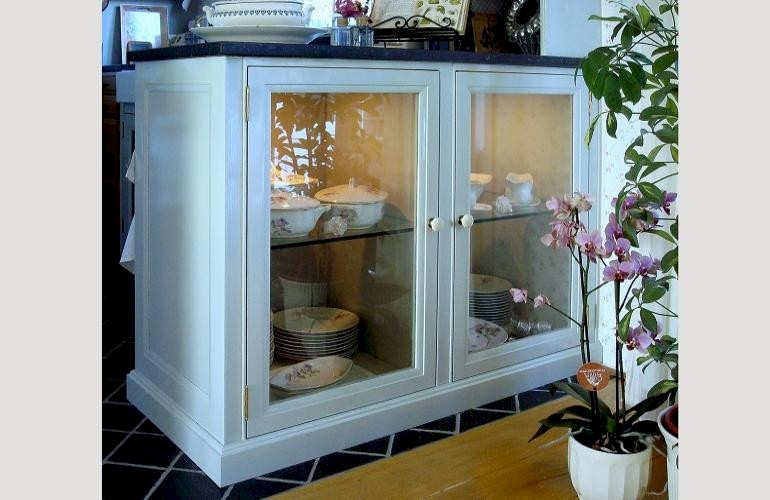 Keuken vitrinekast met planken van glas voor bijzonder porselein.