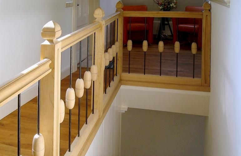 Eiken balustrade met handgesmede spijlen.