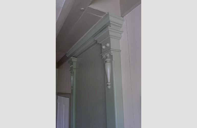 Sierlijk schouwbovenstuk van pilasters.